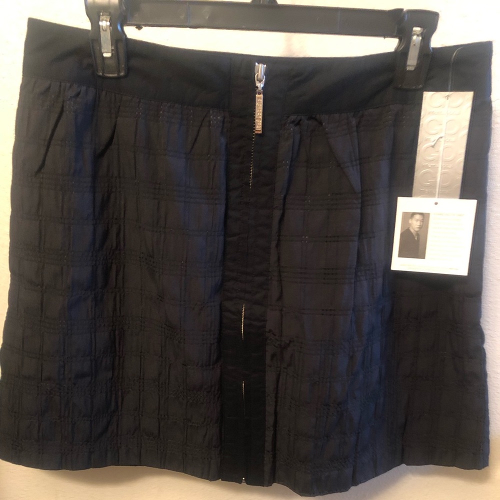 Black skirt, zips up the front with pockets